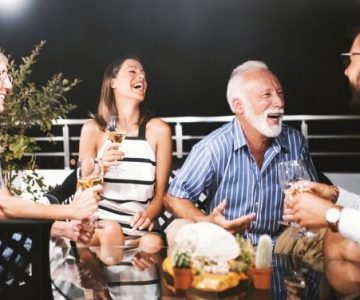 senior couple and friends laughing over dinner