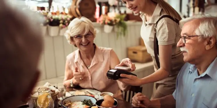 Close up of a group of senior friends having lunch in a restaurant