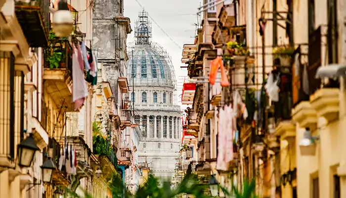 a busy street with a view of the Capitol building of Havana, Cuba