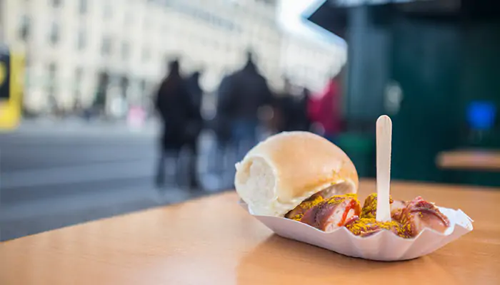 a currywurst with bread roll on a plate