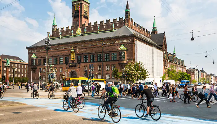 a few cyclists riding in front of a historic building