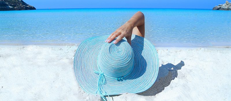 Blue-sun-hat-on-white-sand-beach-clear-blue-sea