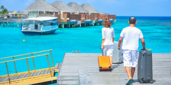 Couple walking with luggage on dock