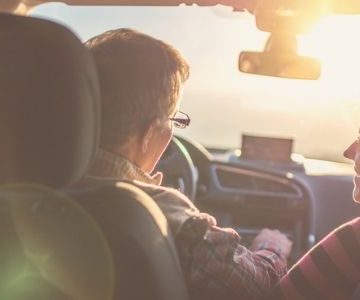 senior couple driving at sunset