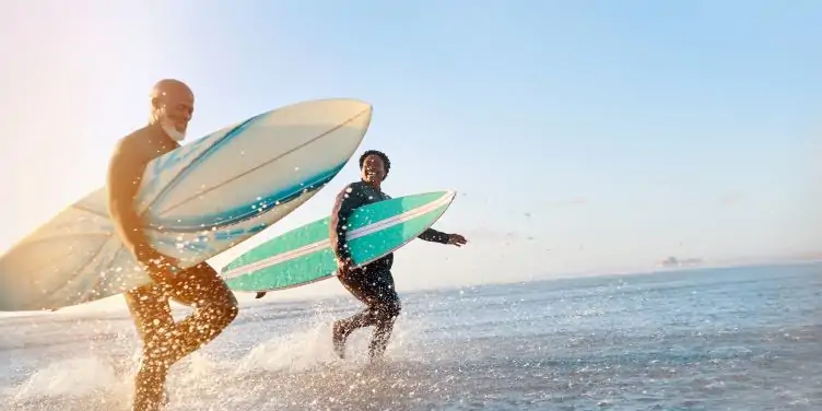 Mature couple surfing at the beach