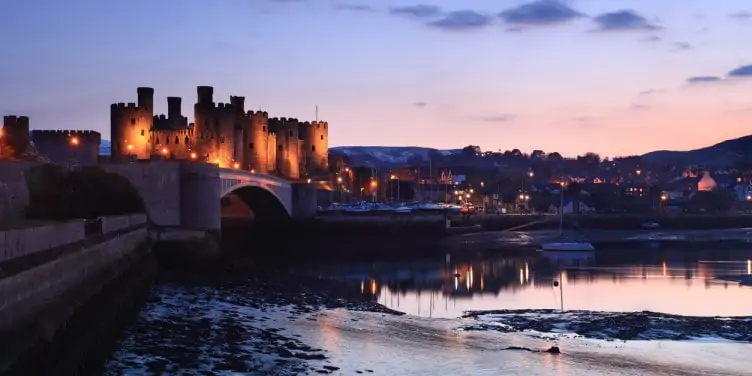 A view of Conway Castle and the harbour at dusk