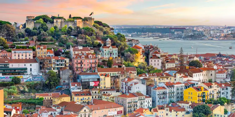 an image of the Lisbon skyline and Sao Jorge Castle at sunset