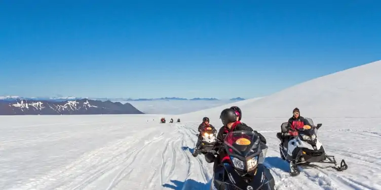 Group of people riding snowmobiles in a glacier in Iceland