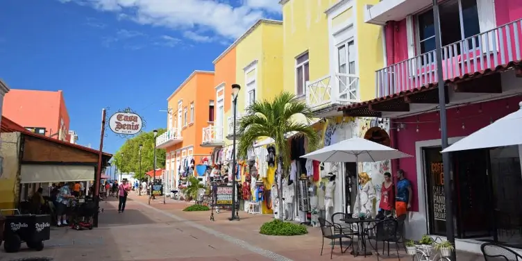 a colourful street lined with restaurants and shops in Cozumel, Mexico