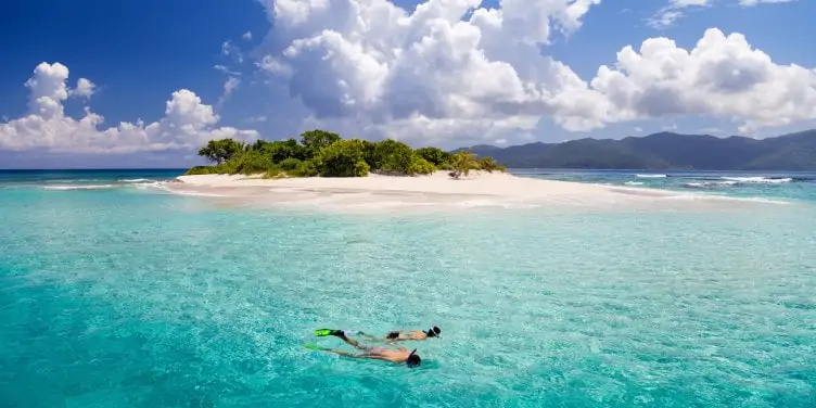 two people snorkelling in the clear blue water just off a small island near St Thomas, US Virgin Islands