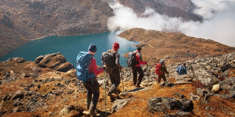 Group of tourists descending down mountain trail in Lantang, Nepal