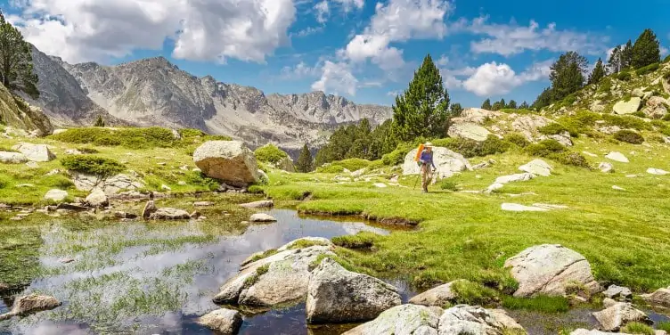 Hiker walking through impressive Pyrenees landscape in Andorra