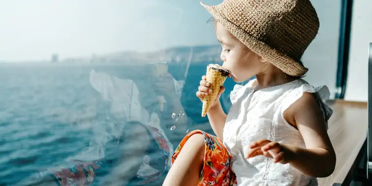 Child eating ice cream while looking out to the open sea