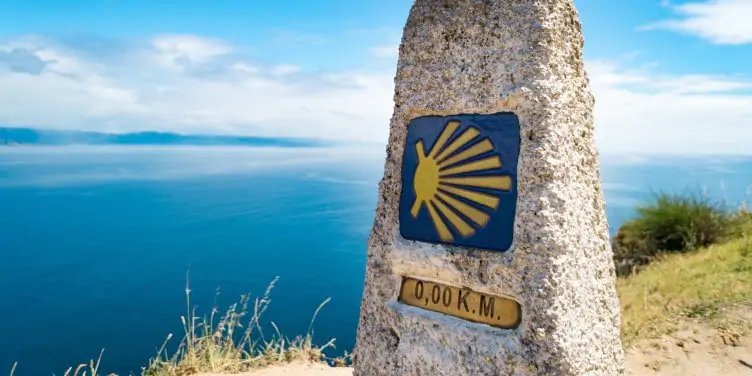Stone milestone marker at Finisterre lighthouse, showing the end of the Camino de Santiago.