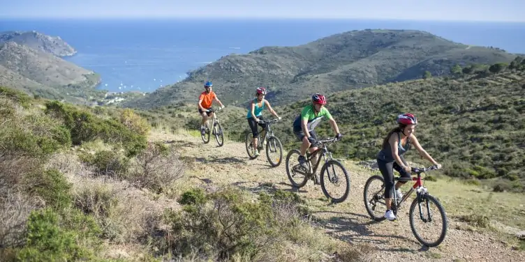 Group of cyclists on an adventure holiday in Spain with the Mediterranean sea in the background.