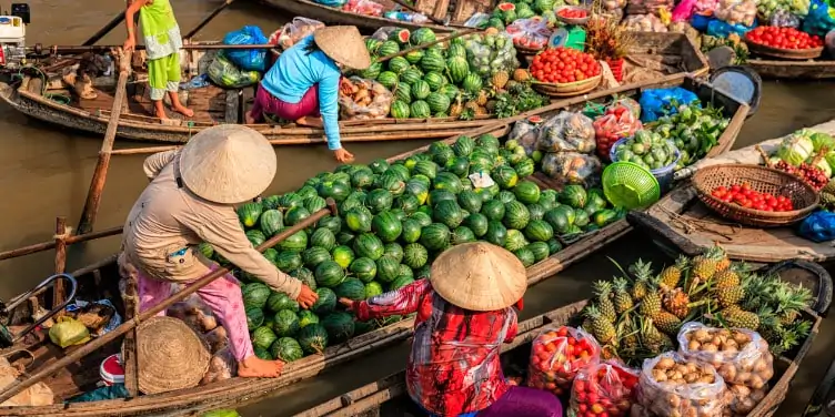Women selling fruits on floating market in the Mekong river delta