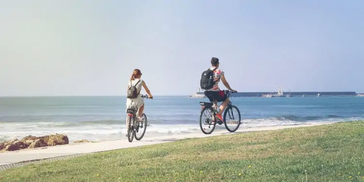 Tourists cycling along the coastline in Porto, Portugal
