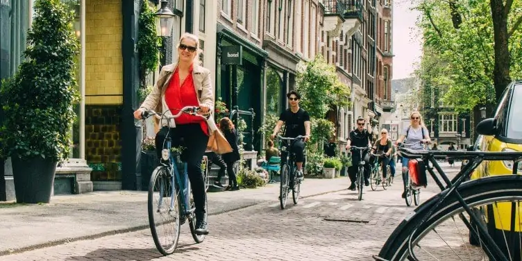 Cyclists make their commutes alongside the townhouses in bike-friendly Amsterdam