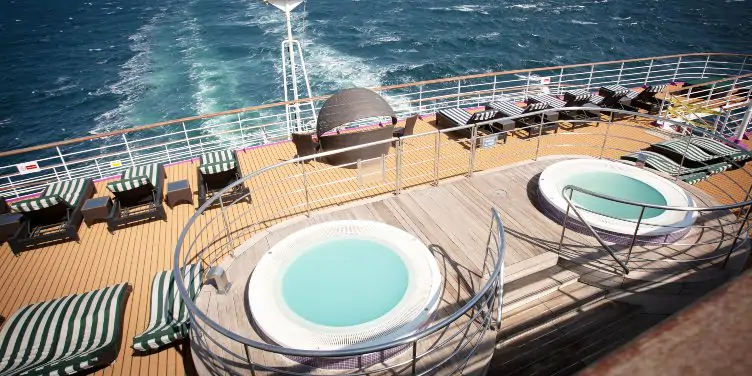 an image of sun loungers and two hot tubs at the back of a cruise ship