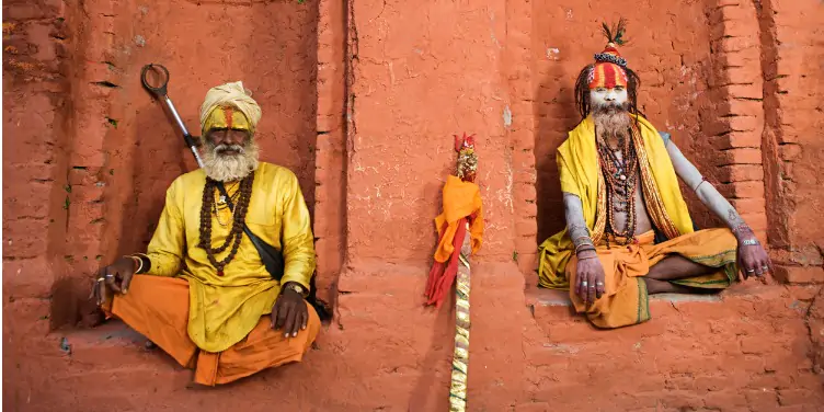 an image of two sadhus in a temple in Nepal, recognisable by their brightly-coloured clothes and painted faces