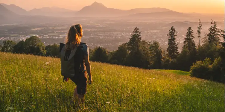 an image of a female hiker on a grassy hill