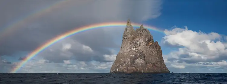 Rainbow arching over Ball’s Pyramid in Australia