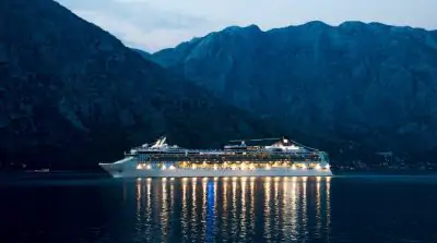 A cruise ship at night in front of mountains