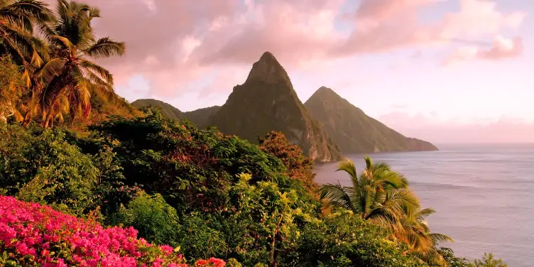 The twin Piton peaks in Saint Lucia with lush greenery in the foreground and the ocean on the right