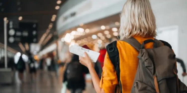 Middle-aged woman walking through the airport with her passport and boarding pass. 