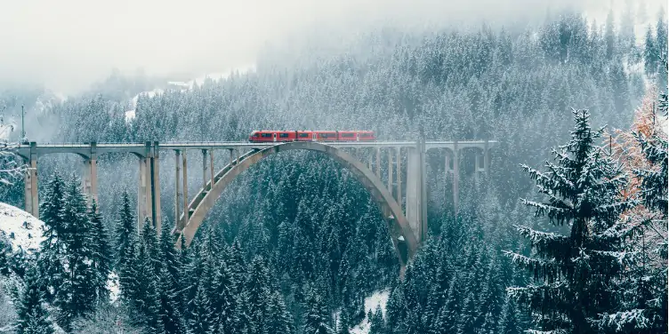 Train crossing viaduct bridge in Switzerland in the winter
