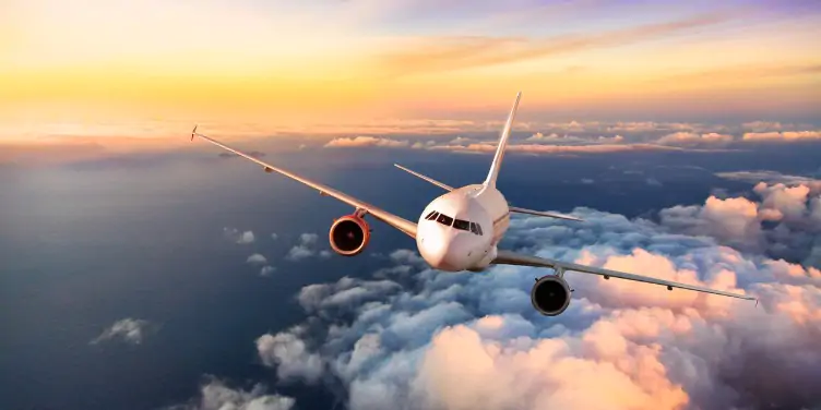 Aeroplane flying above the clouds over Europe at sunset