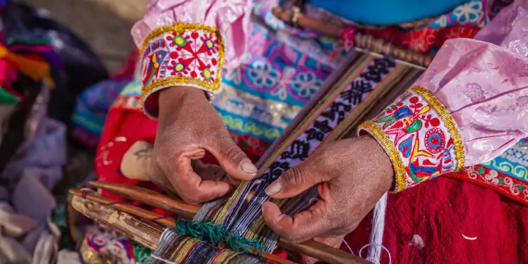 Woman weaving an authentic local handmade souvenir in Peru.
