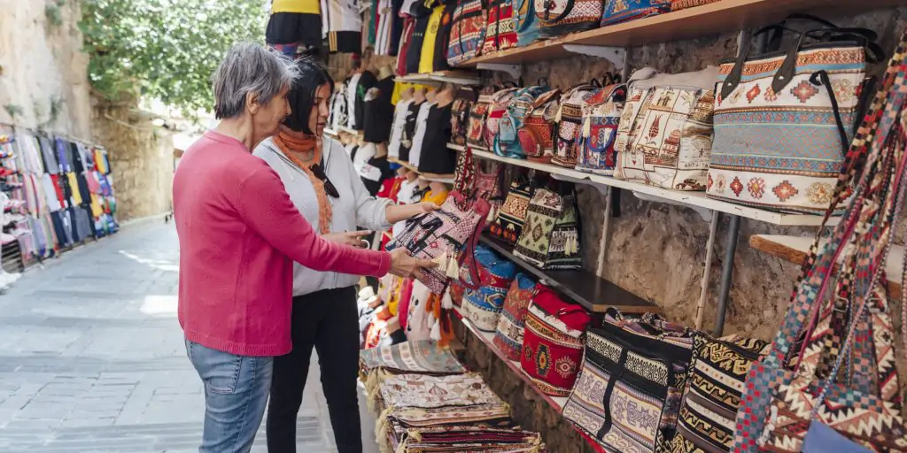 mother and daughter shopping for fabric on an old town market stall