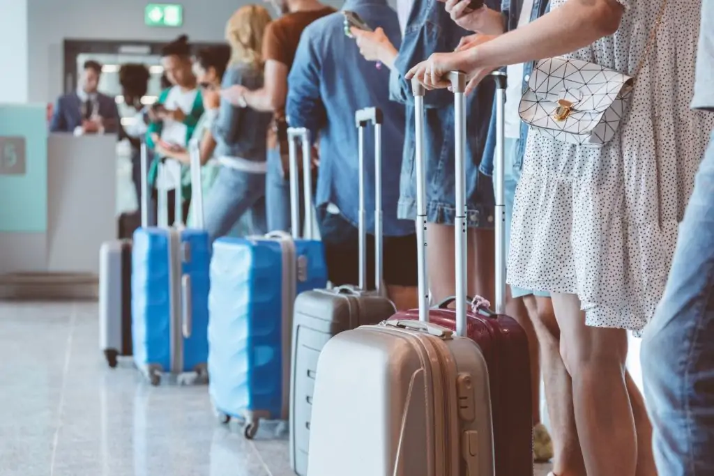 low view of people queuing at an airport with luggage