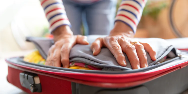 Close-up of an older woman packing her suitcase for her package holiday