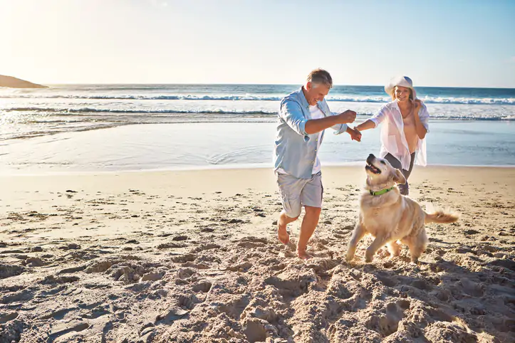 Shot of a mature couple spending the day at the beach with their dog