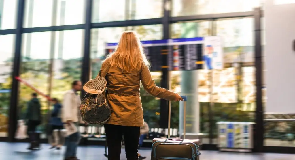 Woman holding luggage and checking flight time