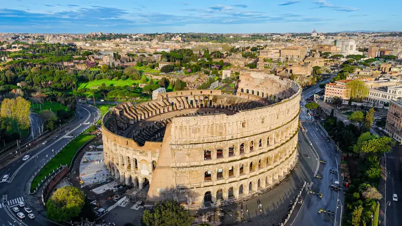 Aerial view of the ancient Colosseum in Rome with panoramic cityscape, iconic Roman amphitheater from different angles including top-down detail, Historical architecture and tourism concept for editorial and travel design